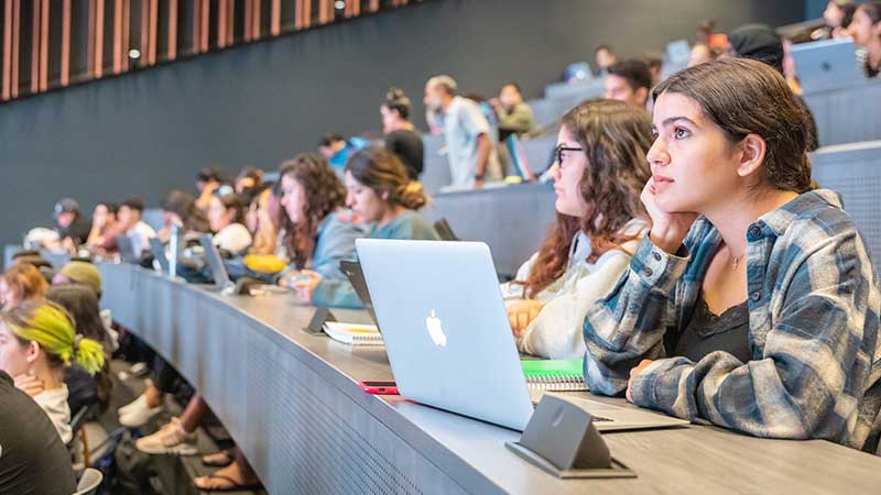 group of students listenting and watching a presentation in class